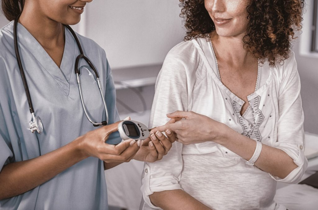 doctor-examining-pregnant-womans-blood-sugar